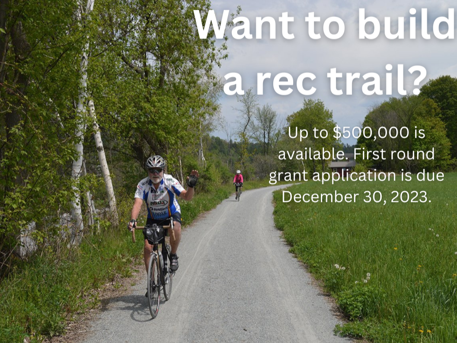 Image of couple riding bikes on a recreation trail. Text reads "Want to build a rec trail? Up to $500,000 is available. First round grant application is due December 30, 2023."