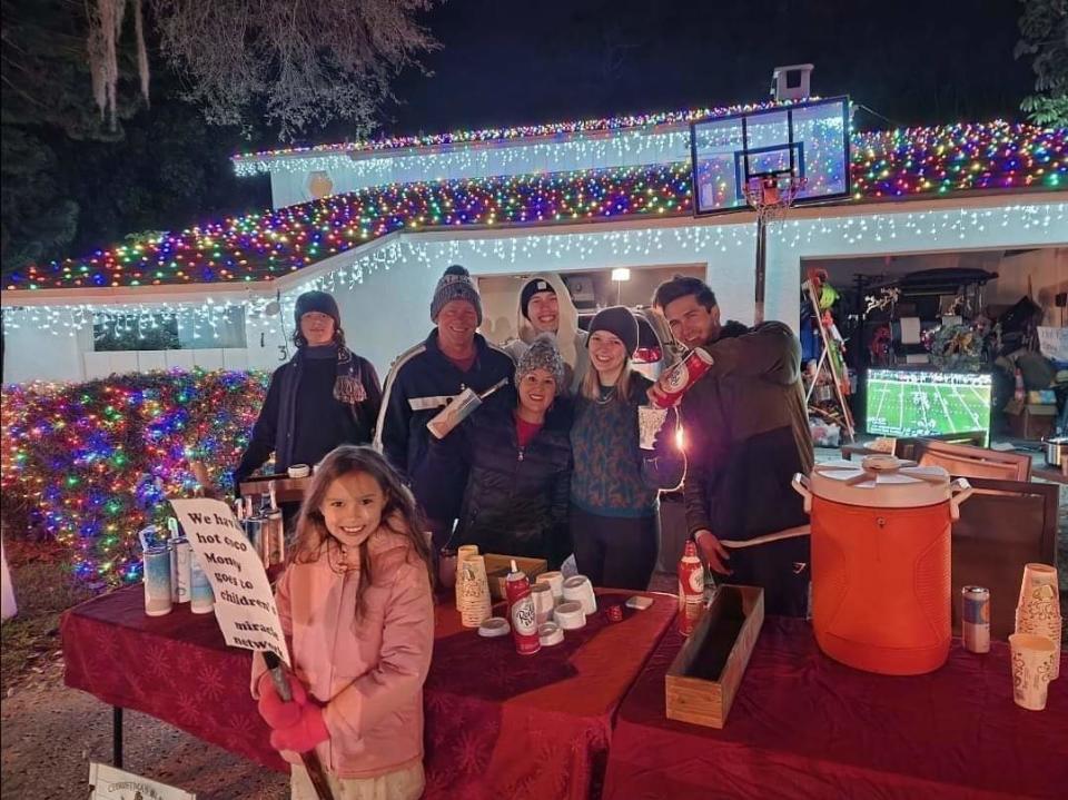 Denis Phillips' house is lit up with holiday lights while his family and friends are gathered around their hot chocolate stand in the Indian Trails subdivision in Palm Harbor, Florida. Phillips' kids sell hot chocolate as a fundraiser to benefit local charities during the neighborhood festivities, which draw thousands of visitors every year. (Photo courtesy of Denis Phillips)