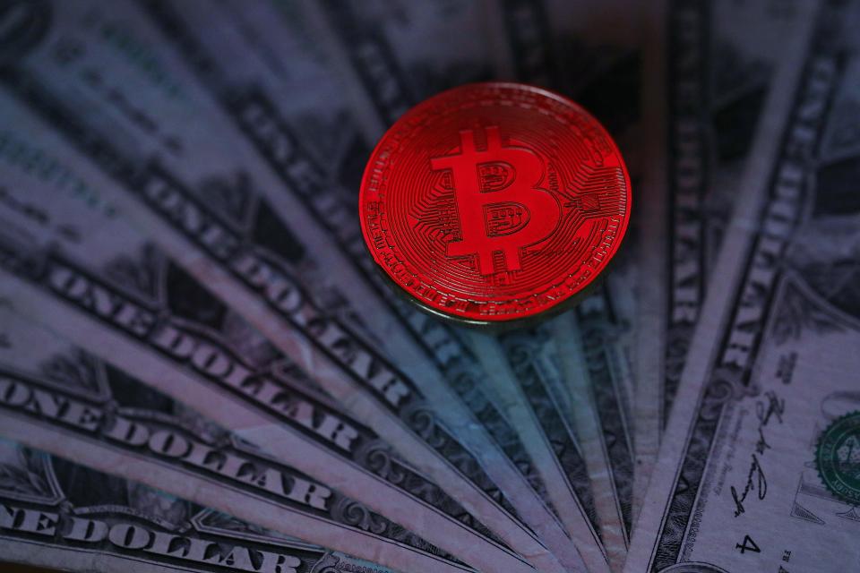 A visual representation of the digital cryptocurrency, Bitcoin, alongside U.S. dollars.