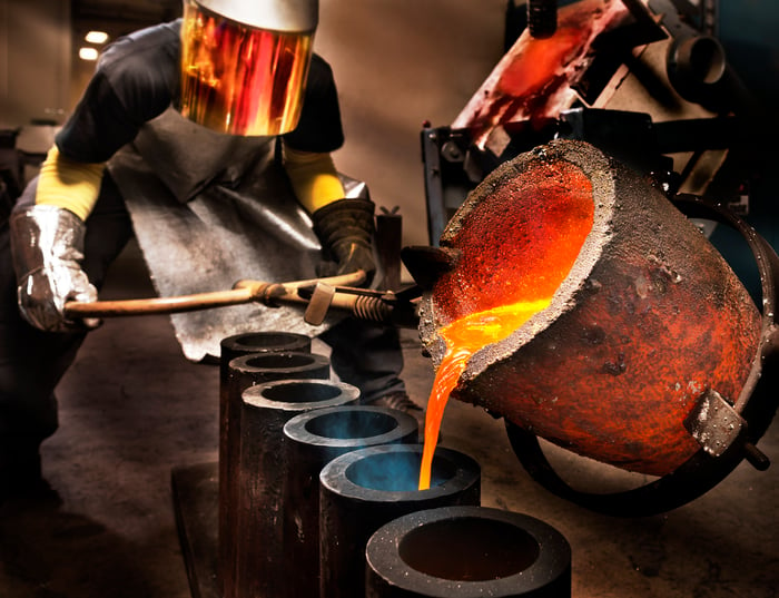 A person pouring molten steel in a steel mill.