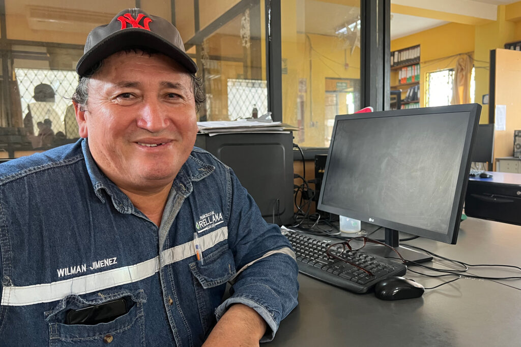 Wilman Jiménez sits at his desk on March 22, 2023 in Orellana Province, Ecuador. Jiménez was detained in solitary confinement at a military site for more than two weeks for attending a march protesting Perenco's operations. Credit: Katie Surma/Inside Climate News