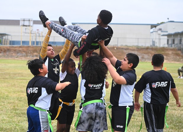 The Saints flag football team lifts up Rashawn Munmon after his one-handed catch helped solidify the team's win against the Ravens during the Coach Sarna League flag football championships on Saturday in Vallejo. (Chris Riley/Times-Herald)