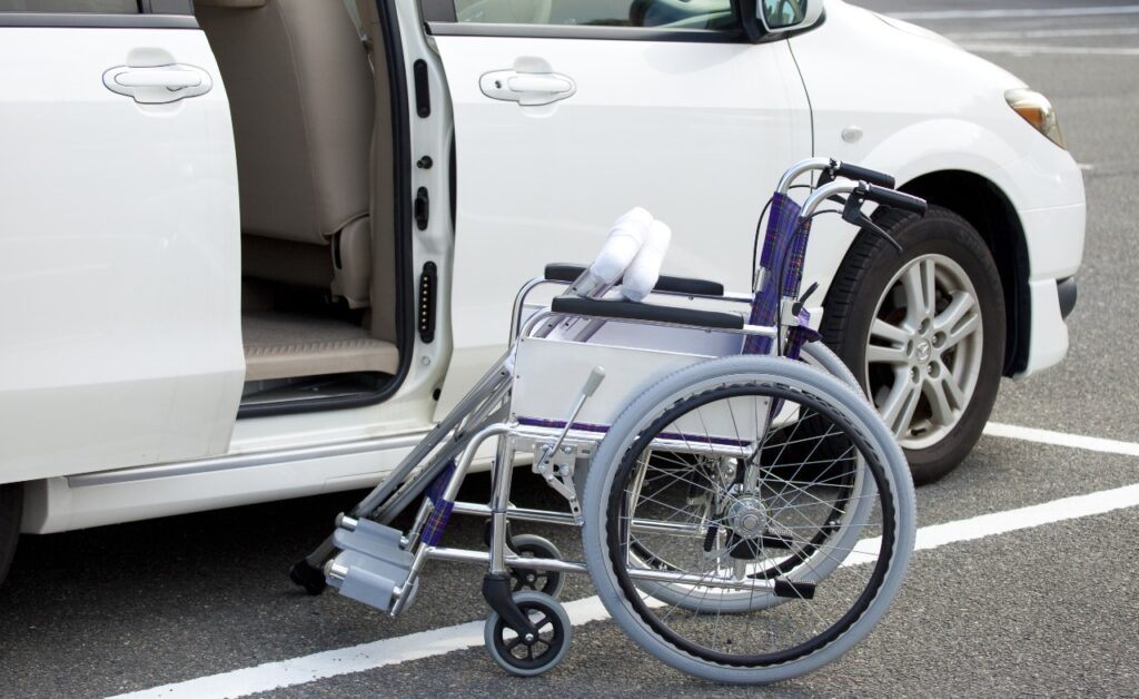 Wheelchair and crutches in front of open minivan door