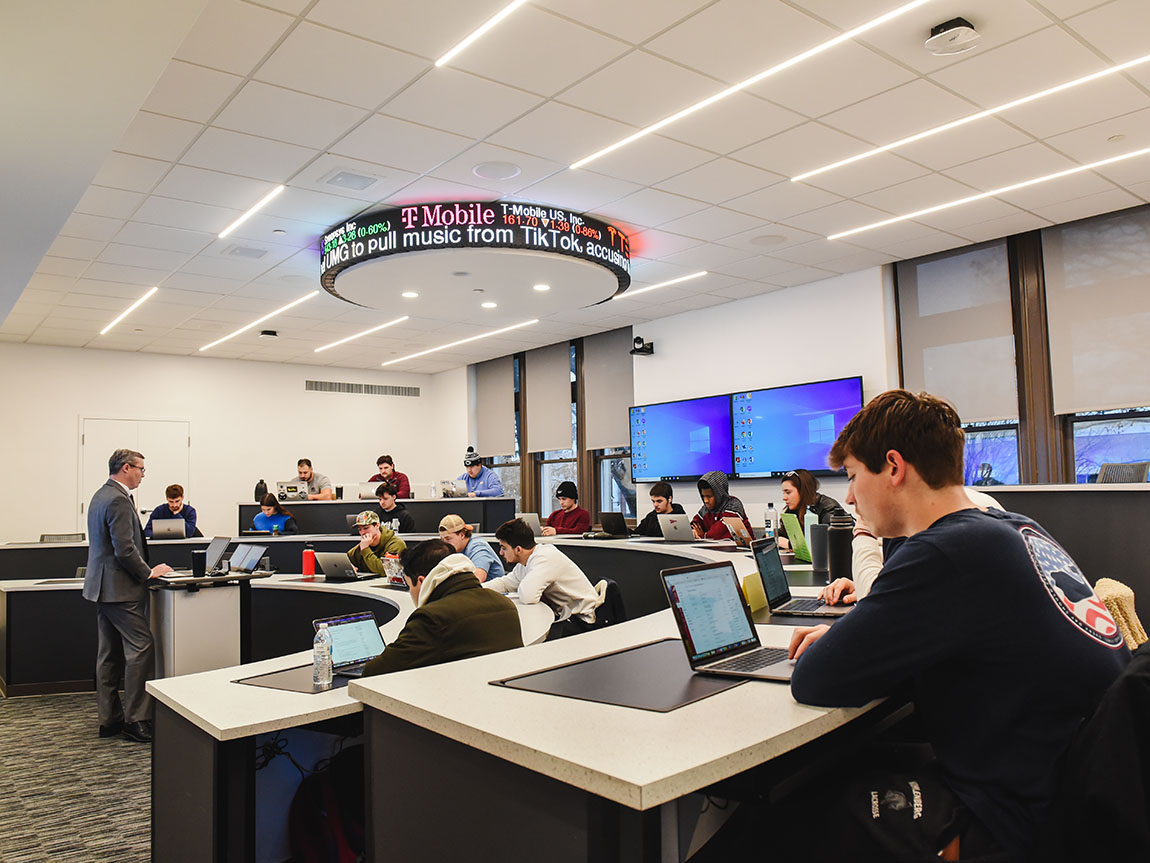 Students take a class in the newly renovated Finance Lab with a stock ticker on the ceiling