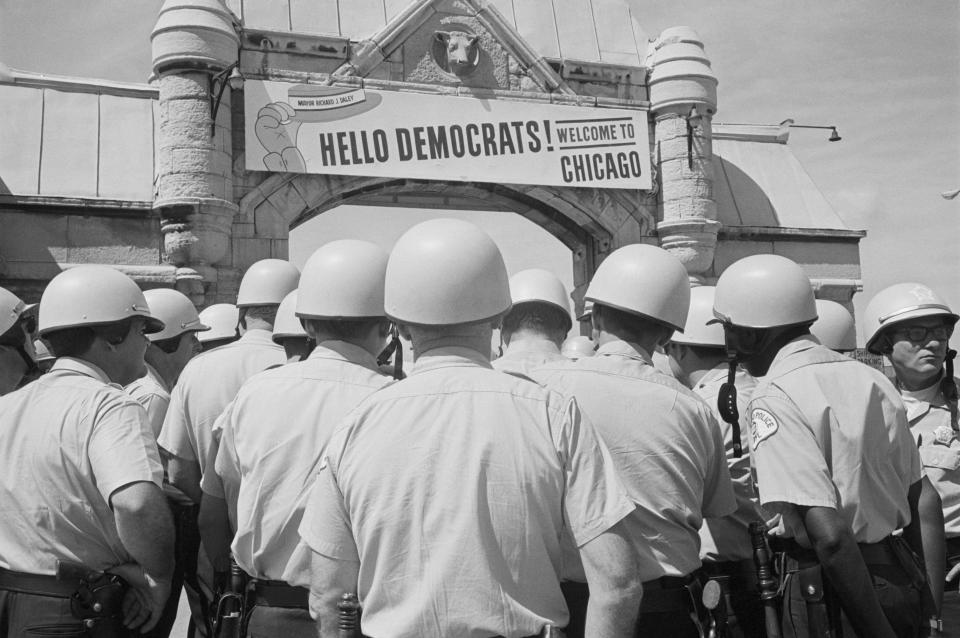 Chicago: The sign over archway leading to the International Ampithetre welcomes delegates to the Democratic National Convention, but from the sea of police helmets in foreground, it looks like only police are attending, 8/26.  8/26/1968