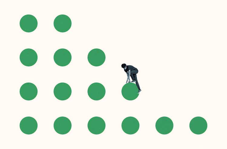 Young courageous man climbing on green circles