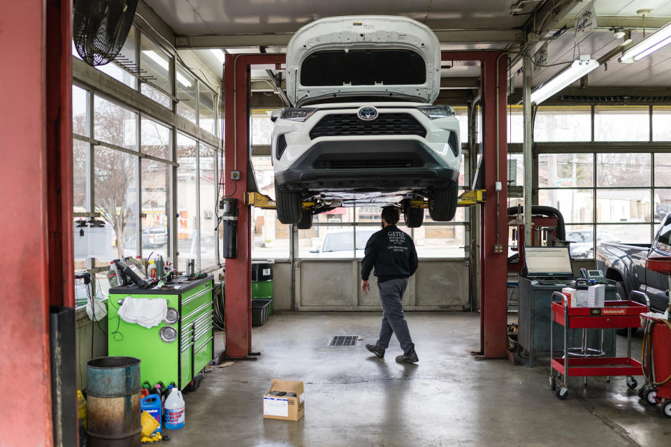LOUISVILLE, KY - JANUARY 13: An auto mechanic walks under a vehicle being repaired from a lift at Gates Automotive Service on January 13, 2022 in Louisville, Kentucky. Due to the global supply chain slowdown and labor shortages, many shops around the US are experiencing difficulty ordering parts and fulfilling service requests. (Photo by Jon Cherry/Getty Images)