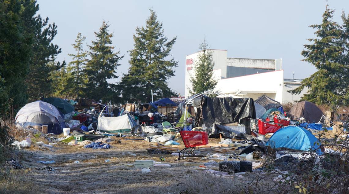 Tents and temporary shelters occupy the property at 4049 Deemer Road near WinCo Foods on Friday, Dec. 16, 2022, in Bellingham, Wash. The city of Bellingham sued the property owner for allegedly causing a public nuisance by not clearing the encampment on the property.