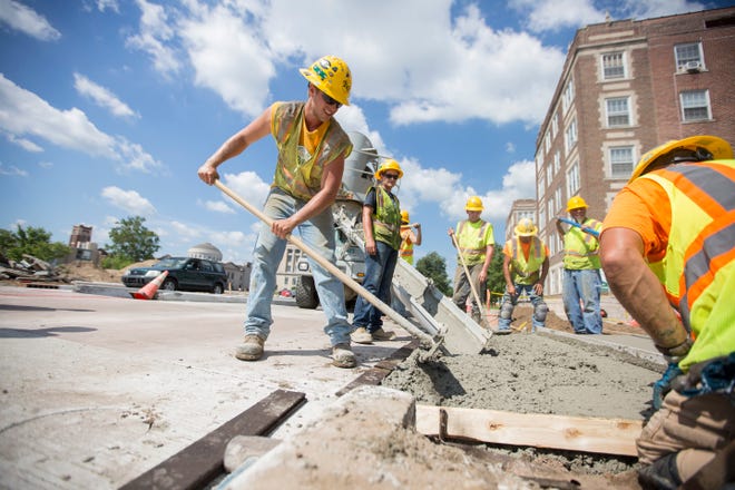 Crews build new sidewalks downtown South Bend in 2016 as part of the city's Smart Streets initiative. After those improvements prompted residents of neighborhoods throughout the city to demand attention, the city has expanded its 2021 curb and sidewalk reimbursement program. Tribune File Photo/Santiago Flores