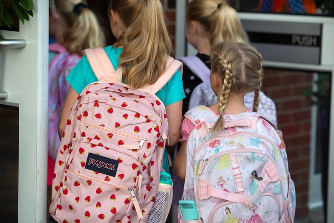 Students with big, colorful backpacks head into Madison Station Elementary School on the first day of school in Madison County Thursday, Aug. 3, 2023.