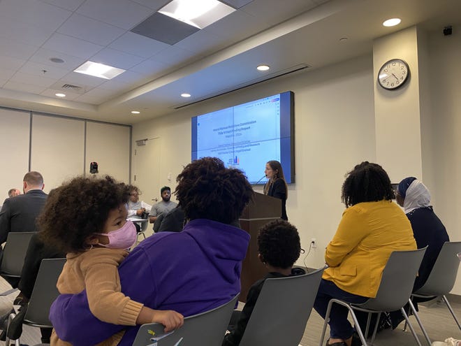Community members and Metro Council members watch as Metro Human Relations Commission Director of Policy and Research Ashley Bachelder explains the findings of an investigation into discrimination complaints regarding Metro Arts Commission grant funding in 2023.