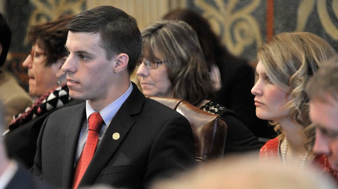 Then-state Rep. Lee Chatfield, R-Levering, sits with his wife, Stephanie, far right, after taking his oath of office in 2015.