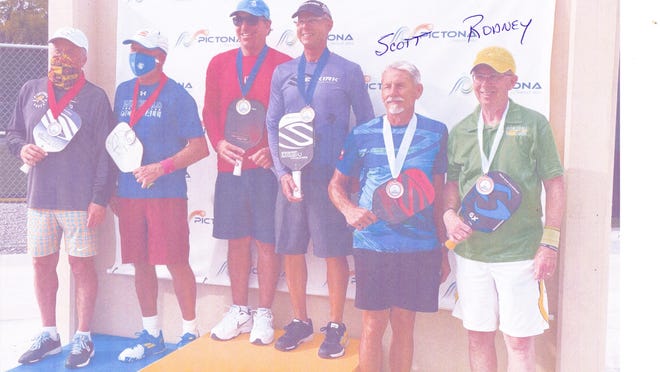 Pickleball Rocks CEO Rodney "Rocket" Grubbs, right, stands next to friend and investor Scott Siewert on the podium after medaling in a doubles match.