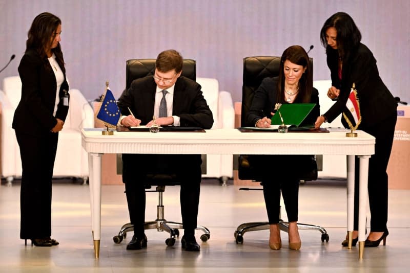 Vice-President of the European Commission Valdis Dombrovskis (L) and Minister of International Cooperation of Egypt Rania Al-Mashat sign an agreement during the Egypt-EU Investment Conference. Dati Bendo/European Commission/dpa