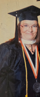 A woman wearing a graduation cap and gown.
