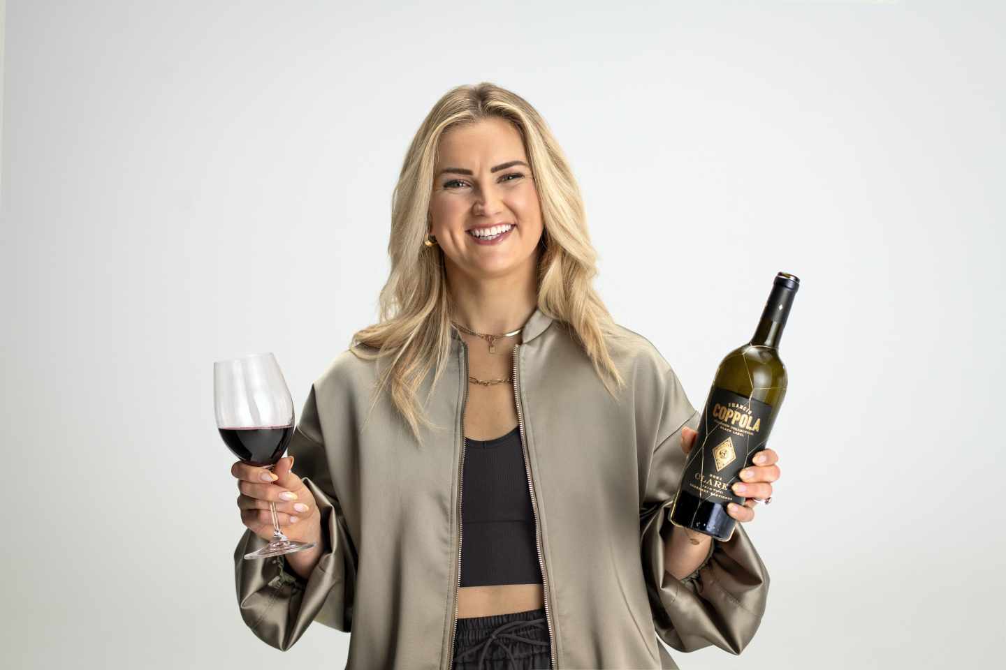 Lindsey Horan holding a bottle of Coppola Wines.