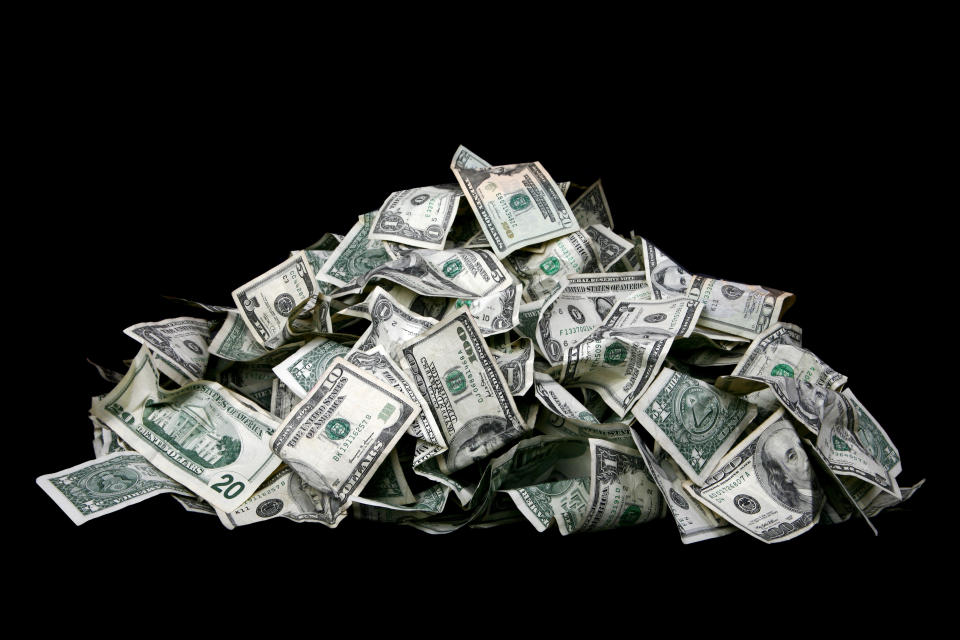 Large stack of cash isolated on black background.