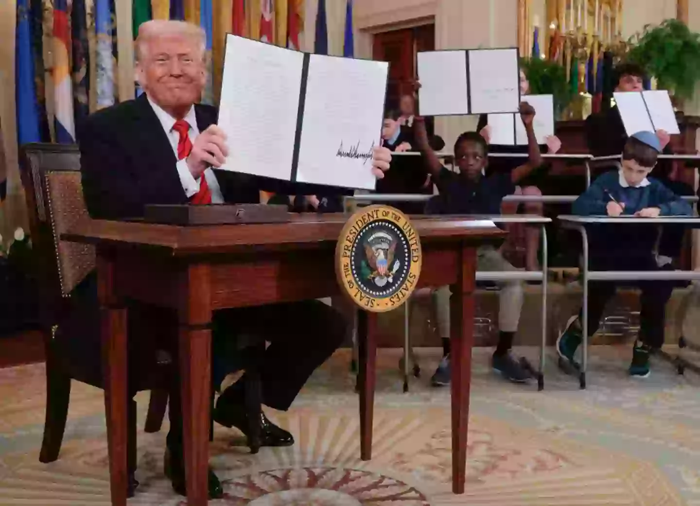 Trump signed the executive order surrounded by school children. (Chip Somodevilla/Getty Images)