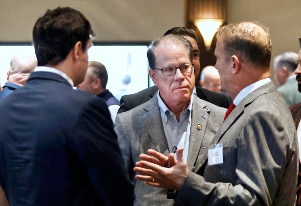 Indiana Governor Mike Braun (center) talks with Dave Pavlik (left), co-founder and managing partner of Decennial Group, and Tom Dakich, CEO of Quantum Corridor, at a luncheon with the Lake County Indiana Economic Alliance at Halls of St. George in Schererville on Thursday, April 3, 2025. (John Smierciak / for the Post-Tribune)