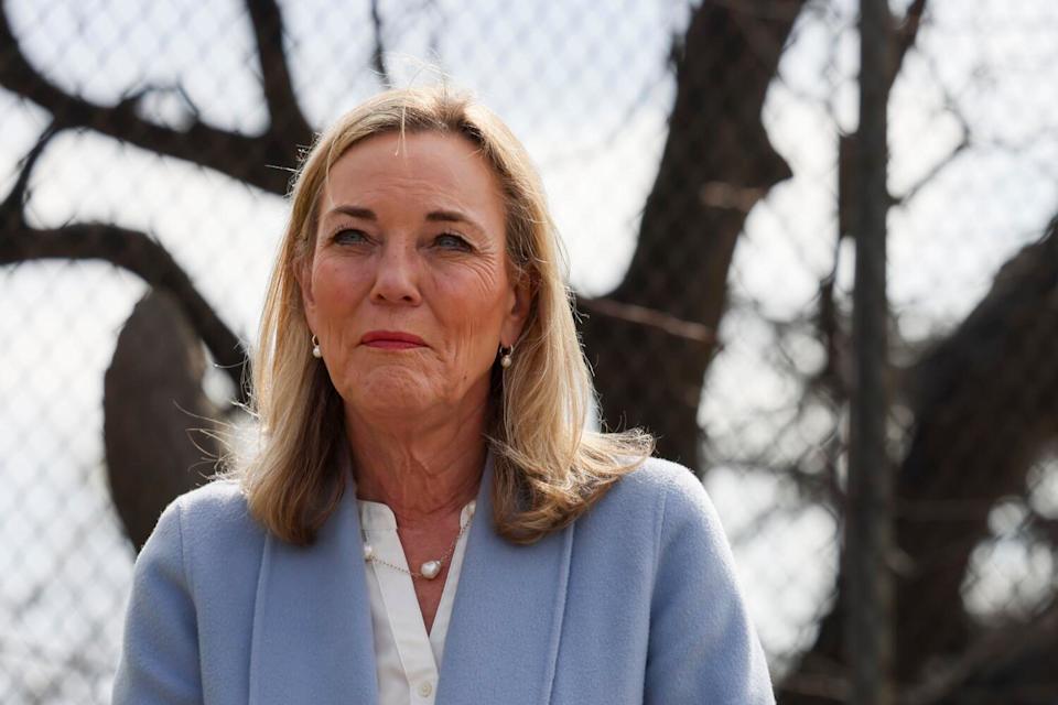 L.A. County Supervisor Kathryn Barger stands near a chain-link fence.