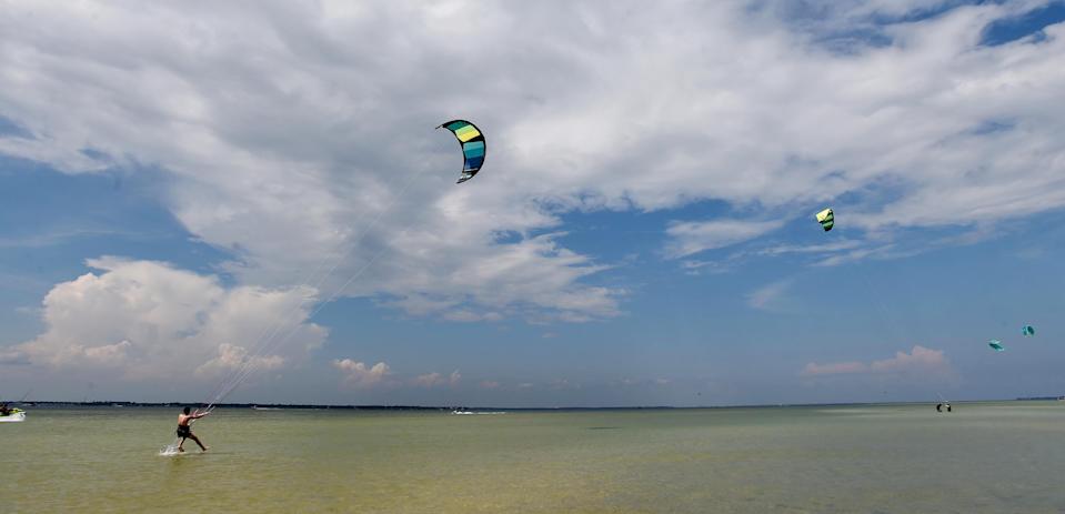 Joseph Greene seems to walk on water as he his pulled along by his kite while practicing his kiteboarding skills Wednesday at Gulf Islands National Seashore Park. Aug. 5, 2020.