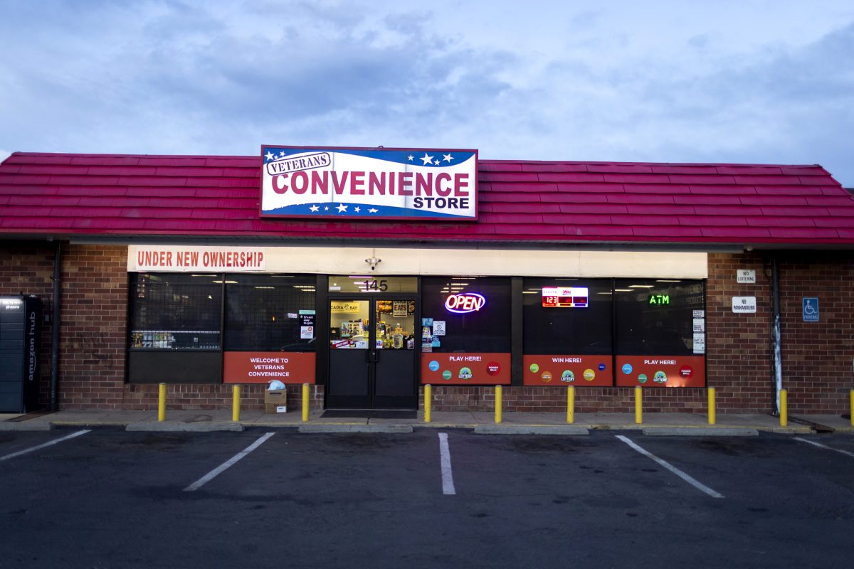 A convenience store with an illuminated ATM sign in the window