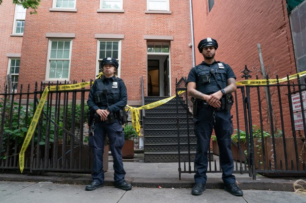 NYPD officers stand outside a home on Prince St. near Mulberry St. in Manhattan on Friday, May 23, 2025, where a man was allegedly held against his will. (Barry Williams / New York Daily News)