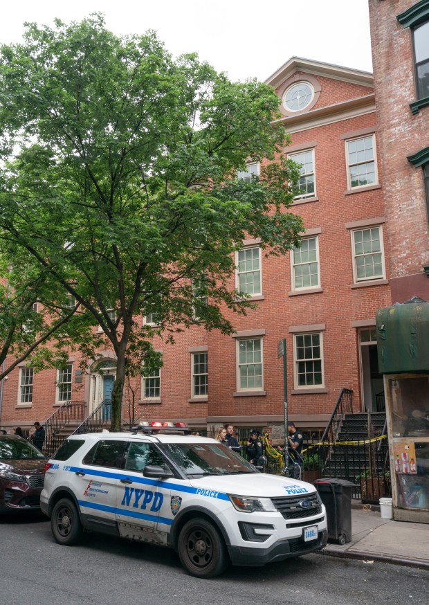NYPD officers stand outside a home on Prince St. near Mulberry St. in Manhattan on Friday, May 23, 2025, where a man was allegedly held against his will. (Barry Williams/ New York Daily News)