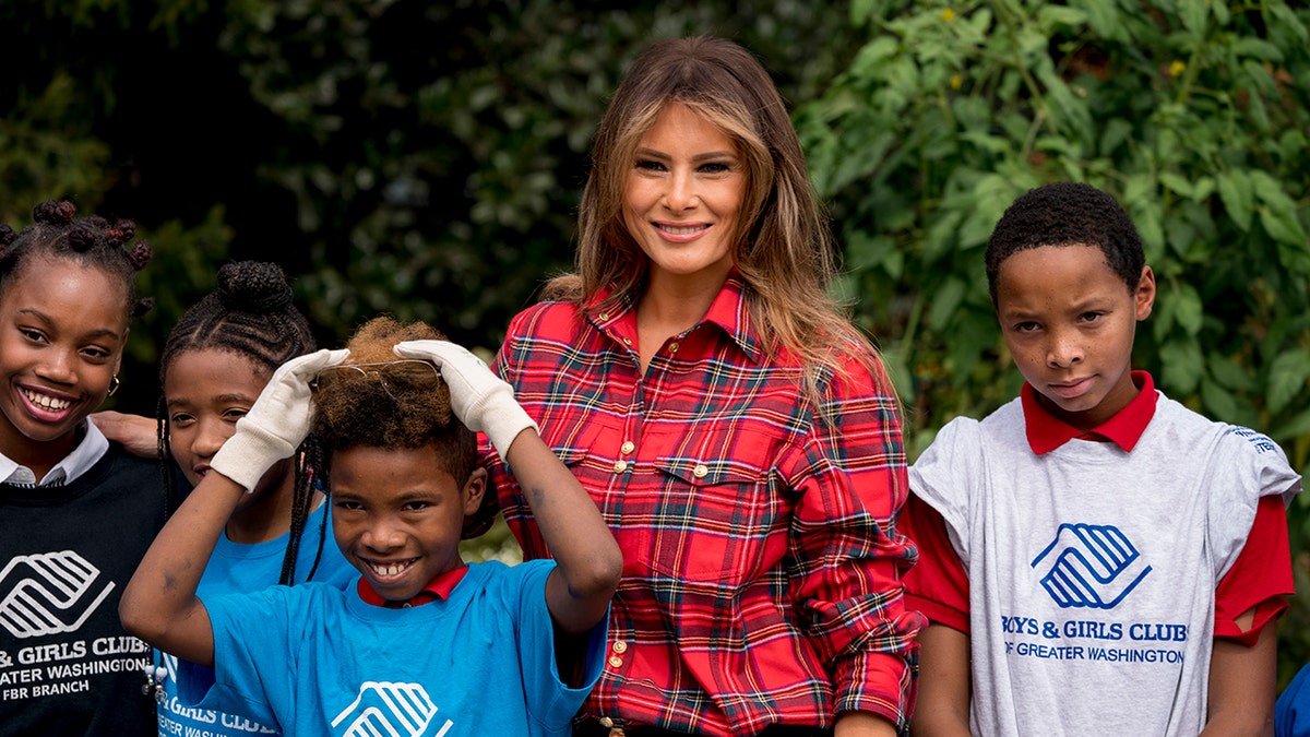 First lady Melania Trump poses with children with the Boys and Girls Club of Washington in the White House Kitchen Garden on the South Lawn of the White House, Friday, Sept. 22, 2017, in Washington. (AP Photo/Andrew Harnik)