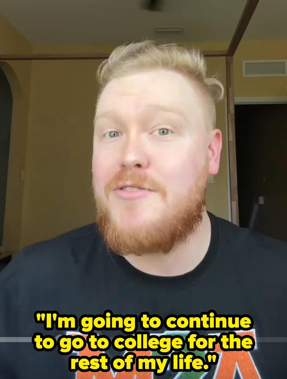 Person with a beard speaking indoors, wearing a shirt that says a and m