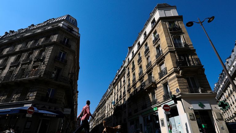 A woman walks her dog on rue Pache street, near the location where a masked gang attempted to kidnap the daughter of a crypto businessman, in Paris, France, May 14, 2025. REUTERS/Gonzalo Fuentes
