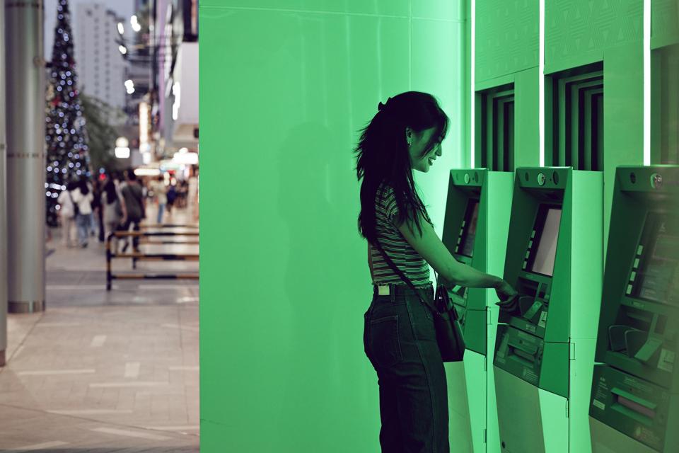 Woman using ATM machine at street