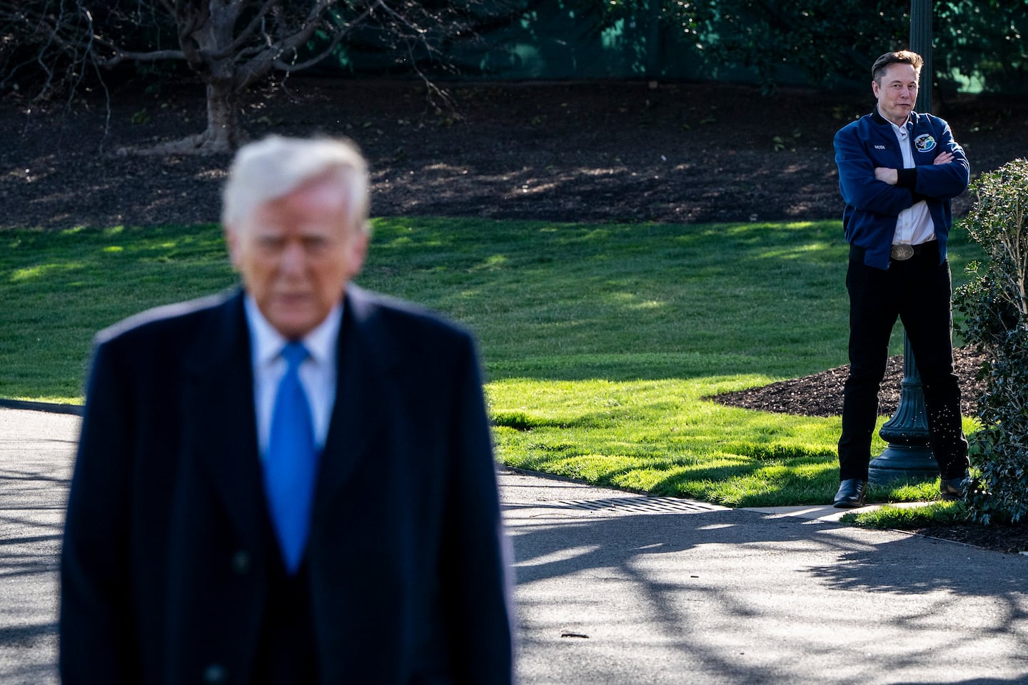 Elon Musk watches as President Trump speaks to reporters outside the White House in Washington, March 21, 2025.