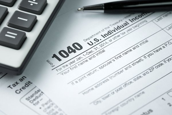 A 1040 tax form with pen and calculator.