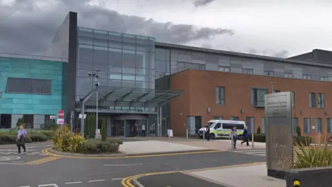 Google The Northern Centre for Cancer Care at the Freeman Hospital. The building has a red-brick section to the right. The main entrance is in the middle and is made predominantly from glass.