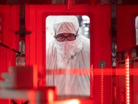 An employee monitors a wafer transfer at one of Texas Instruments’ 300mm semiconductor fabs in Sherman, Texas, SM1.
