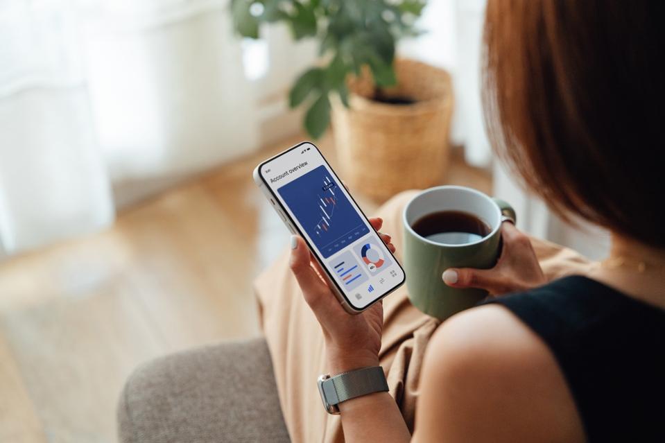Young woman managing bank account with mobile banking app on smartphone