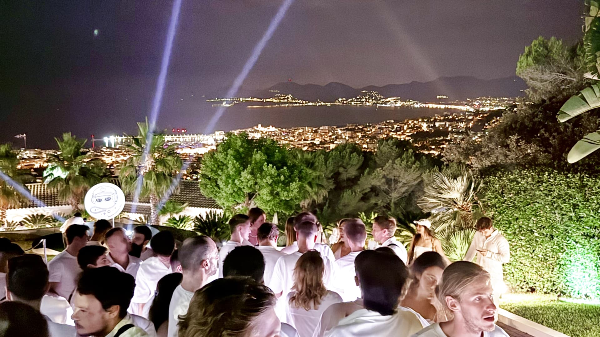White-clad guests dance poolside at the rAAVE party in Cannes.