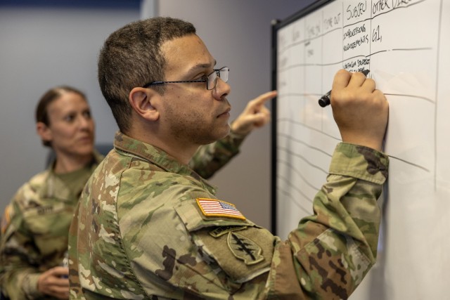 MSG Marcus Pirela, 45th Finance Center, plans and operations advisor, marks a board as MAJ Sonja Keith, 45th FC Chief of Operations, makes remarks during a staff exercise at the Major General Emmett J. Bean Federal Center in Indianapolis, Oct. 28,...