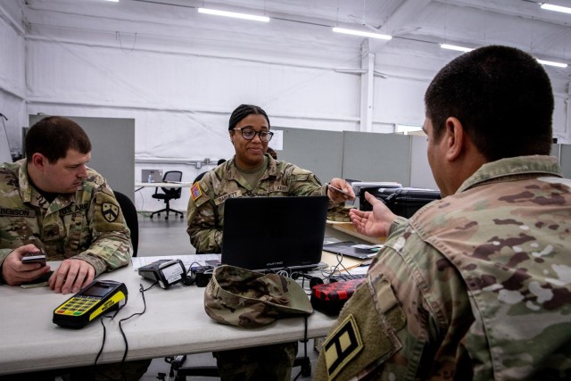 PFC Genesis Barnett of the 1128th Finance Management Support Detachment, Tennessee Army National Guard, hands an activated Eagle Cash Card to a Soldier during a mock financial exercise at Fort Cavazos, Texas, Sept. 12, 2024.