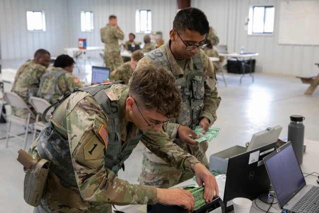 Army Reserve SGT Brandon Froelich (left) and SPC Bhavish Ranjetkar, financial management tacticians assigned to the 374th Financial Management Support Detachment, count and put away simulated currency during a training exercise at Joint Base...
