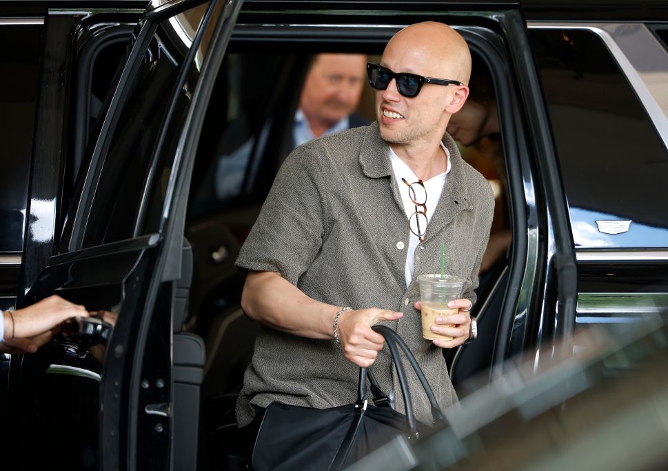 Man in grey shirt and black sunglasses steps out of car