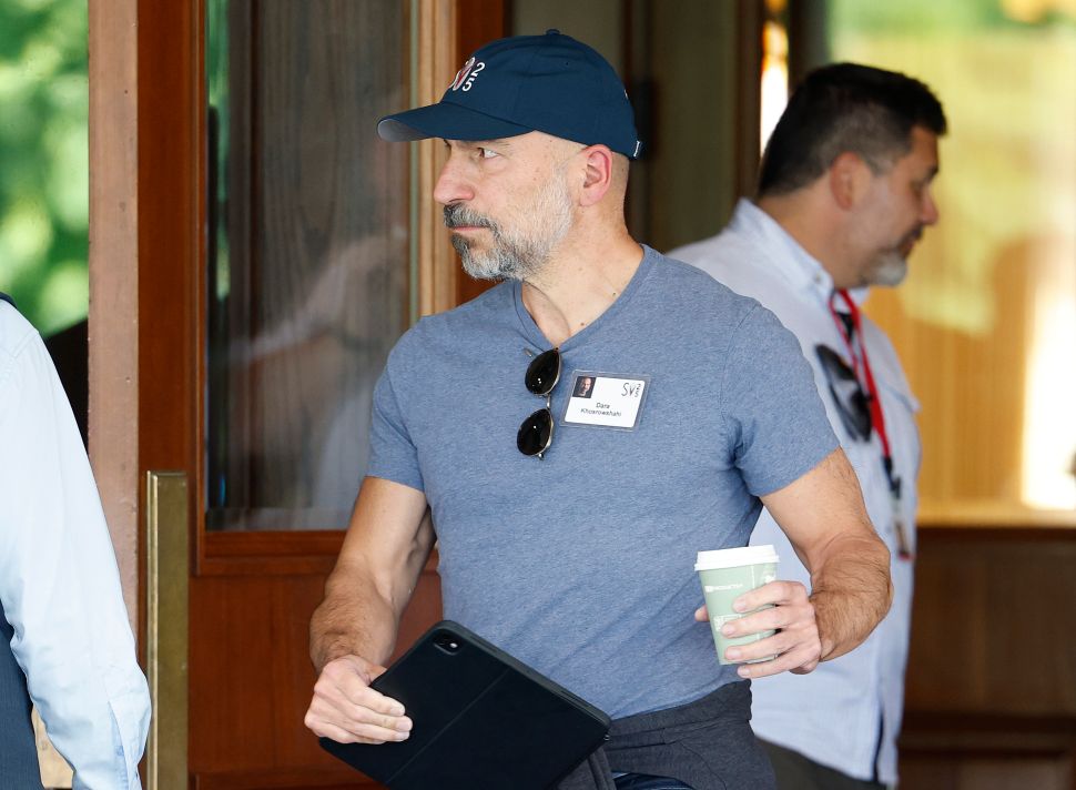 Man in blue shirt and baseball cap walks outside door