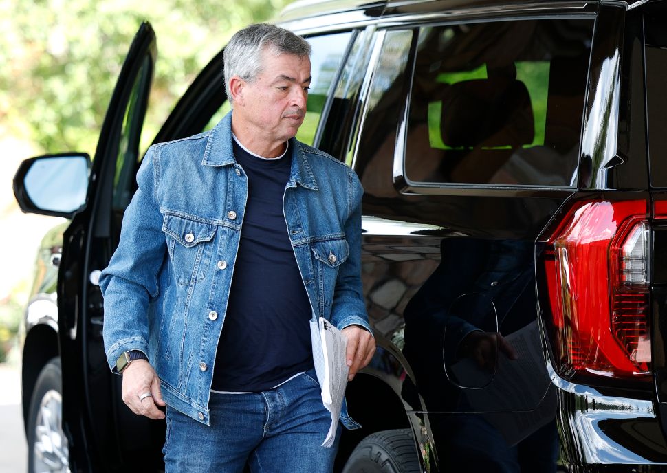 Man in denim overshirt walks out of car 
