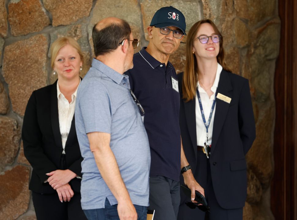 Man in baseball hat and blue shirt walks outside 