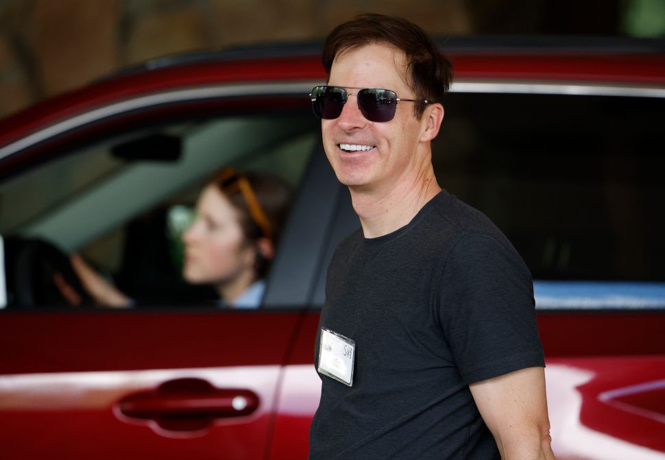 Man in black tshirt and sunglasses walks outside
