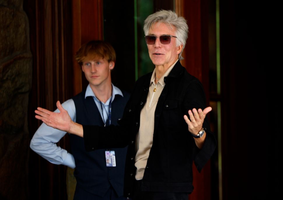 Man in black shirt and sunglasses walks outside