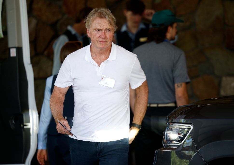 Man in white shirt walks outside