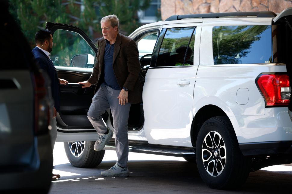 Man in black blazer steps out of car
