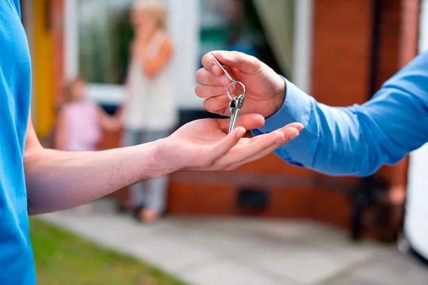 young couple clinch the deal with their estate agent